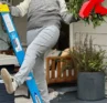 Photo of Molly Booker on a ladder with a wreath