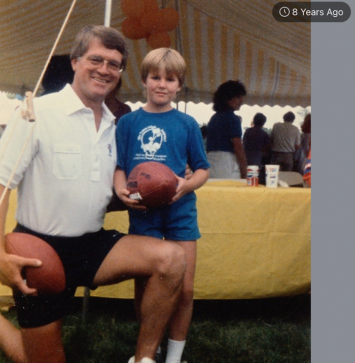Photo of an older person and a younger person holding footballs