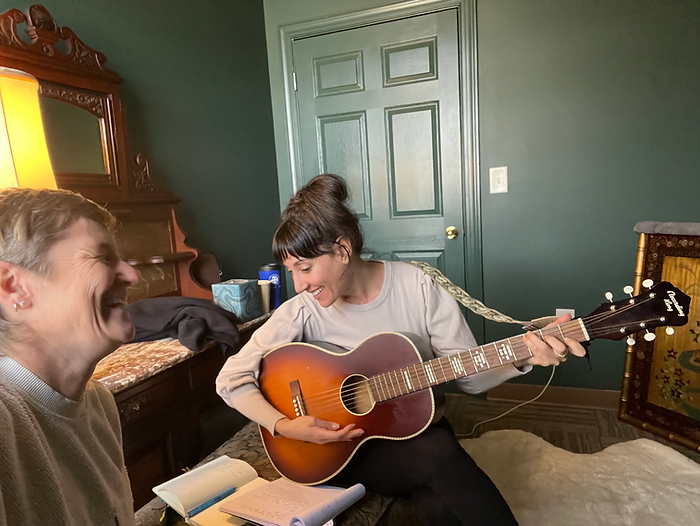 Molly Booker singing while a friend plays guitar