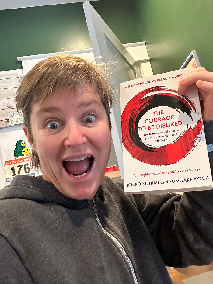 Molly Booker holding a copy of the book The Courage to Be Disliked