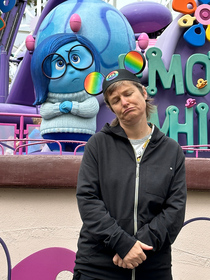 Photo of Molly Booker wearing rainbow Mickey Mouse ears